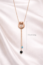 Rose gold necklace with pendant on a satin background, showing length measurement.