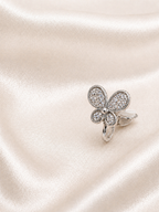 Silver butterfly-shaped earring with clear stones on a satin surface.Elegant butterfly earrings with smooth single diamonds anti-tarnish comfort jewellery for sensitive ears