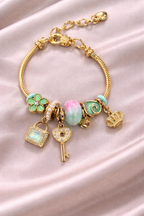 Anti-tarnish charm bracelets for women with green clover, opal bead and crown charms in gold plated demi-fine comfort jewellery by Ashaarya.