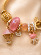 Detailed view of balloon charm, blush pink beads and pearl accents on Pink Postcards bracelet for women