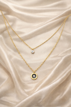 dual layer, anti tarnish, ashaarya, ashaarya jewels, ashaarya jewellery, charm bracletes, Two gold necklaces with pendants on a beige satin background