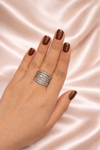 Noor Jaal anti-tarnish statement ring adjustable silver band rings for women comfort jewellery statement rings for women Ashaarya Hand wearing a silver ring with dark nail polish on a pink satin background