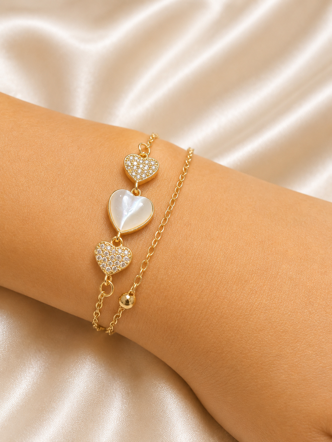The Whispering Hearts Bracelet by Ashaarya featuring 18KT gold plating, mother of pearl hearts, cubic zirconia, anti-tarnish 316L stainless steel comfort jewellery.